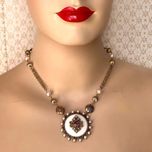 Load image into Gallery viewer, circular white pendant embellished with faux pearl beads and amethyst rhinestone on a fine chain modelled on a mannequin
