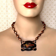 Load image into Gallery viewer, necklace featuring a copper coloured bird on a black and copper coloured frame with matching beads displayed on a mannequin
