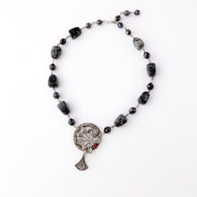 Load image into Gallery viewer, necklace in silvery greys with a red rhinestone set focal displayed flat on a white background

