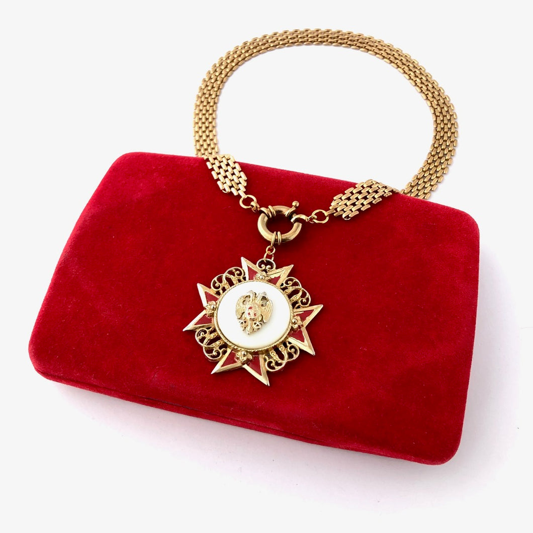 necklace made with vintage Maltese cross pendant, chain and clasp displayed on a red velvet jewellery boxon 