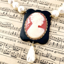 Load image into Gallery viewer, close up of cameo focal and pearlised beads on vintage music paper
