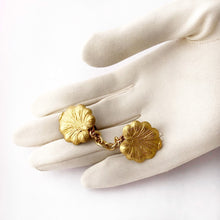 Load image into Gallery viewer, short sweater guard  made with vintage lily pad shaped stampings displayed on a gloved hand
