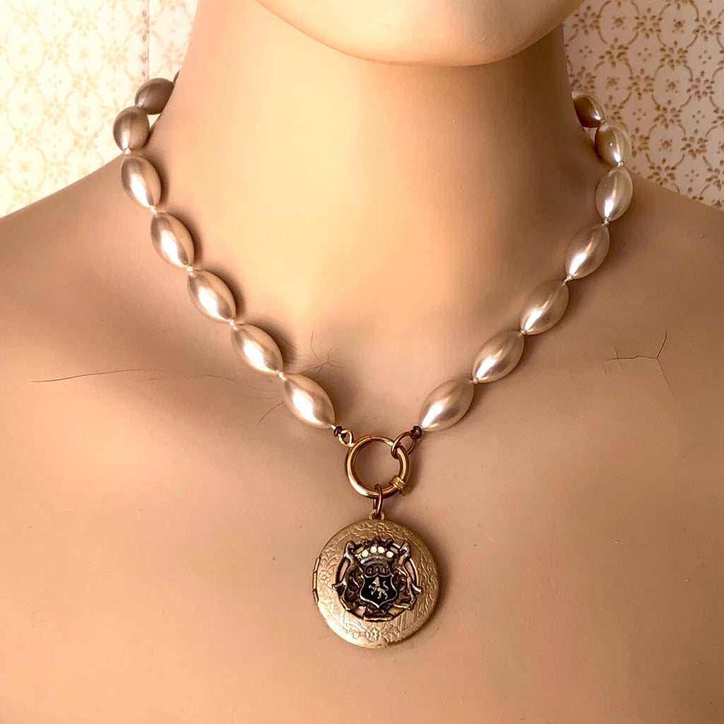 mannequin wearing a pearl bead necklace with vintage locket suspended from the front