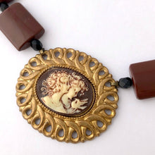 Load image into Gallery viewer, close up of a a cameo necklace featuring two women and a bird, with chocolate brown and black beads
