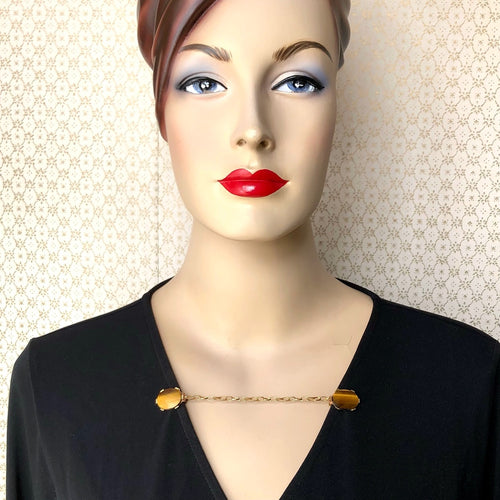 mannequin wearing a wrap dress accessorised with a sweater guard made with Tiger's Eye gemstones
