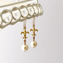 Load image into Gallery viewer, earrings made with pearl beads and fleur-de-lys hanging from a white frame
