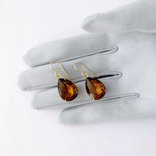 Load image into Gallery viewer, pear shaped smoky topaz rhinestone earrings displayed on a gloved hand
