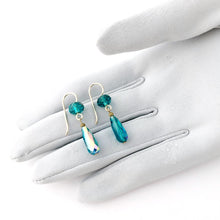 Load image into Gallery viewer, teal glass drop earrings on a gloved hand
