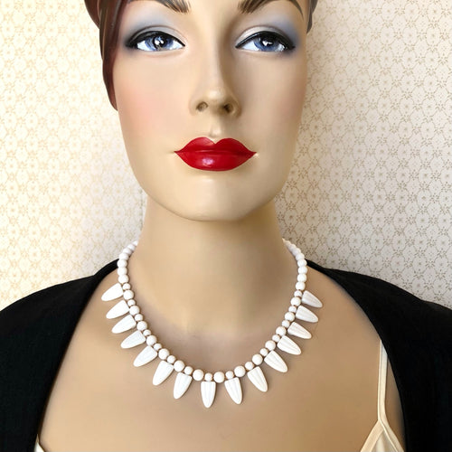 a necklace of repurposed vintage milk glass beads displayed on a mannequin